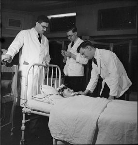 Photo: male nurses assist an English doctor, 1943